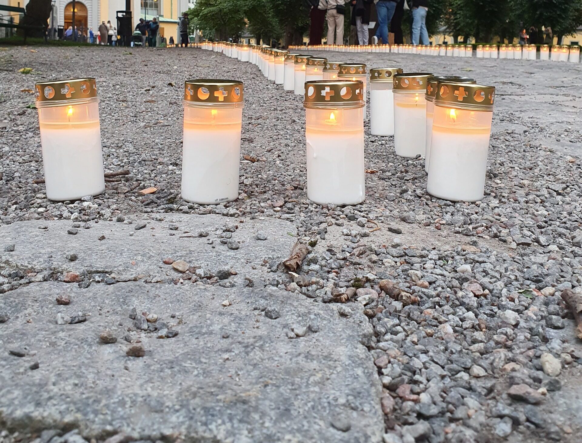 Rad av gravljus vid en minnesstund på kvällen